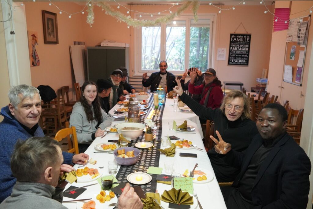 Groupe de personne qui partage un repas de Noel autour d'une table